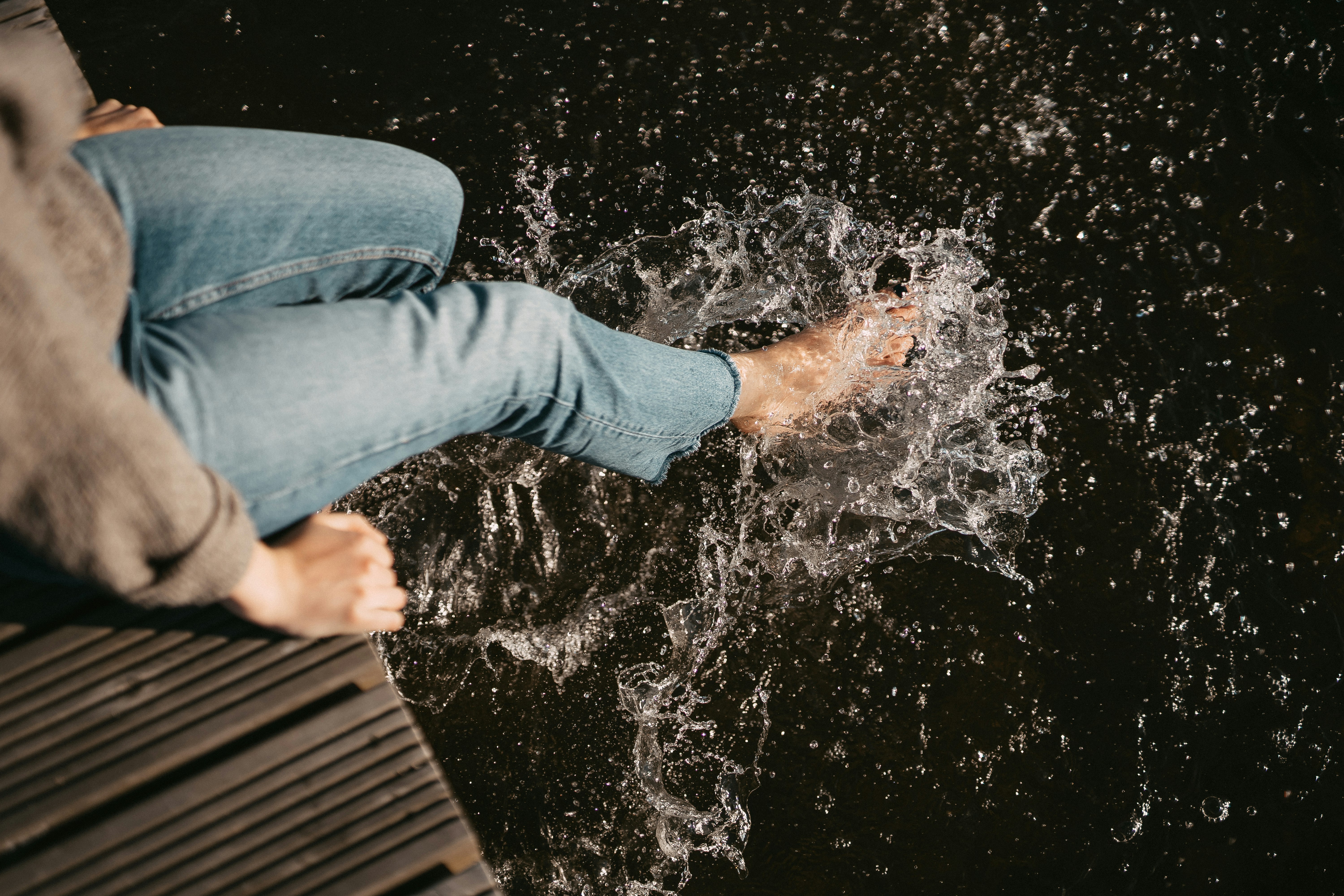 woman wearing blue denim jeans siting on dock